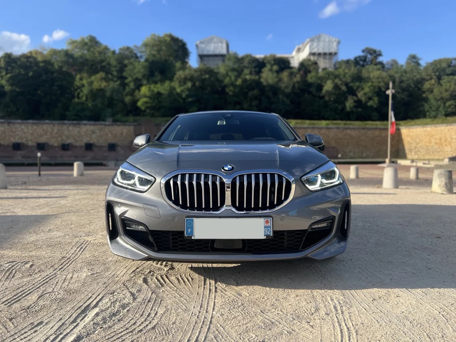 BMW Série 1 2023 gris Storm Bay, finition M Sport, vue 3/4 avant — miniature 2